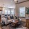 Spacious and well lit living room with carpeted floors and access to the kitchen 