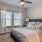 Spacious and well lit bedroom with carpet and a large window 