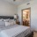 Spacious and well lit bedroom with carpet and a large window 